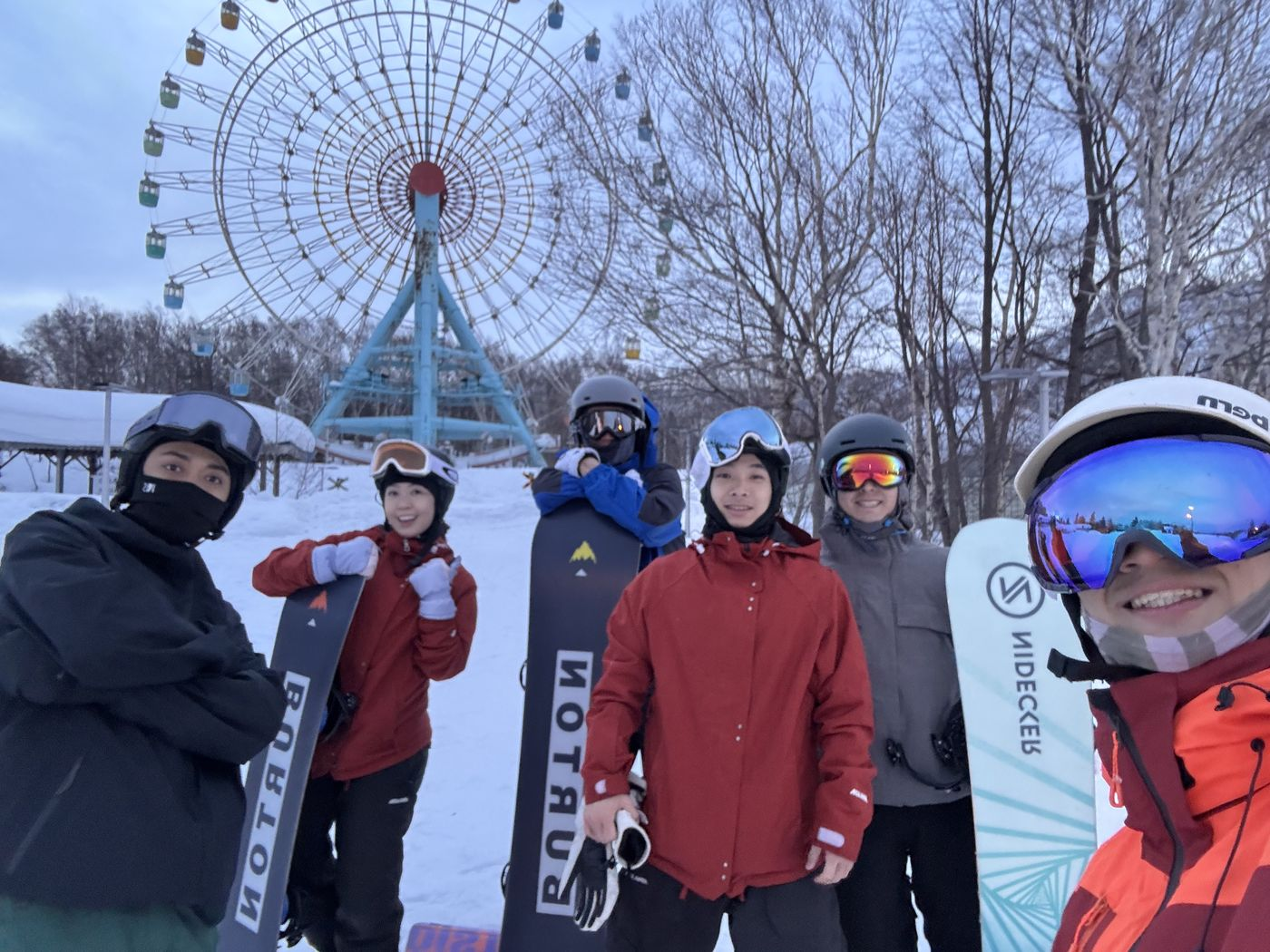 企鵝滑雪學校小班學員在手稻 Olympia 區大觀覽車前合照